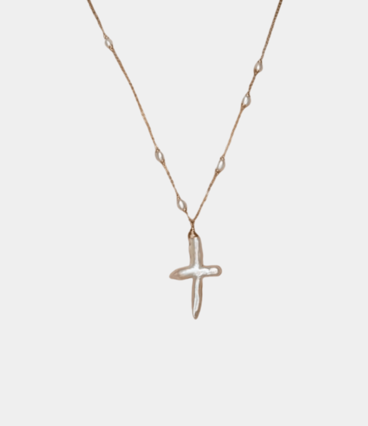ANGEL PEARL CROSS necklace with a gold-tone fine chain and an irregular white pearl cross pendant.