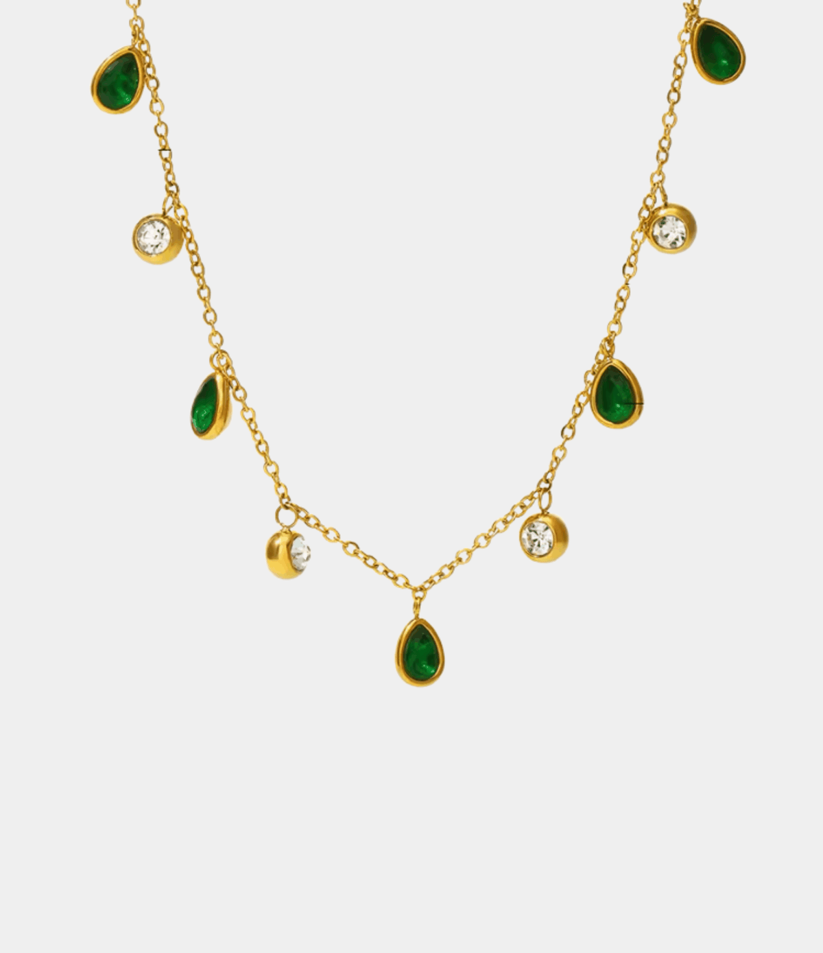 DIANA NECKLACE IN GREEN with a gold-tone chain, alternating green teardrop stones and round clear accents.