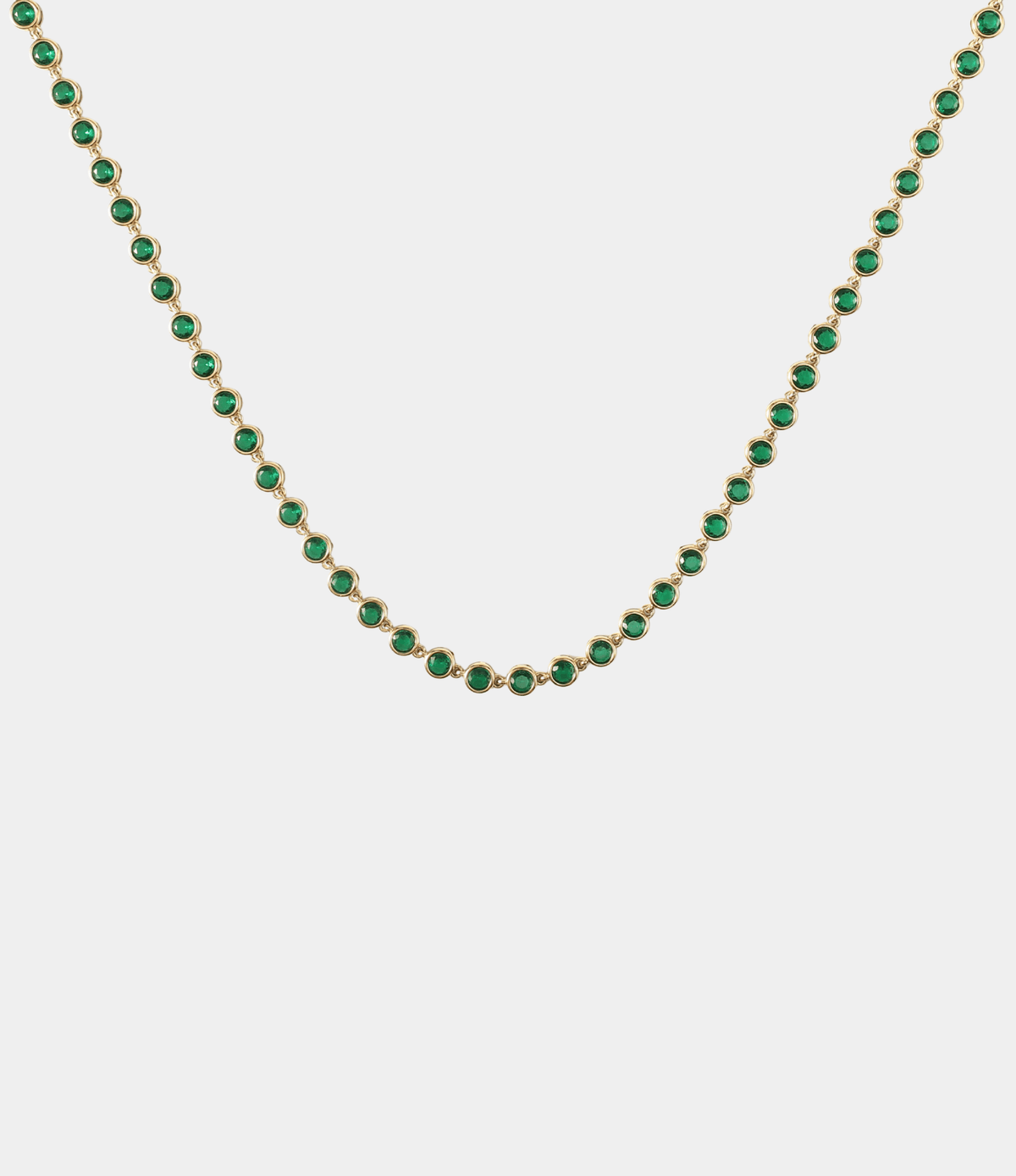 VIVIAN TENNIS NECKLACE with a row of round green stones in gold-tone settings and a delicate chain.