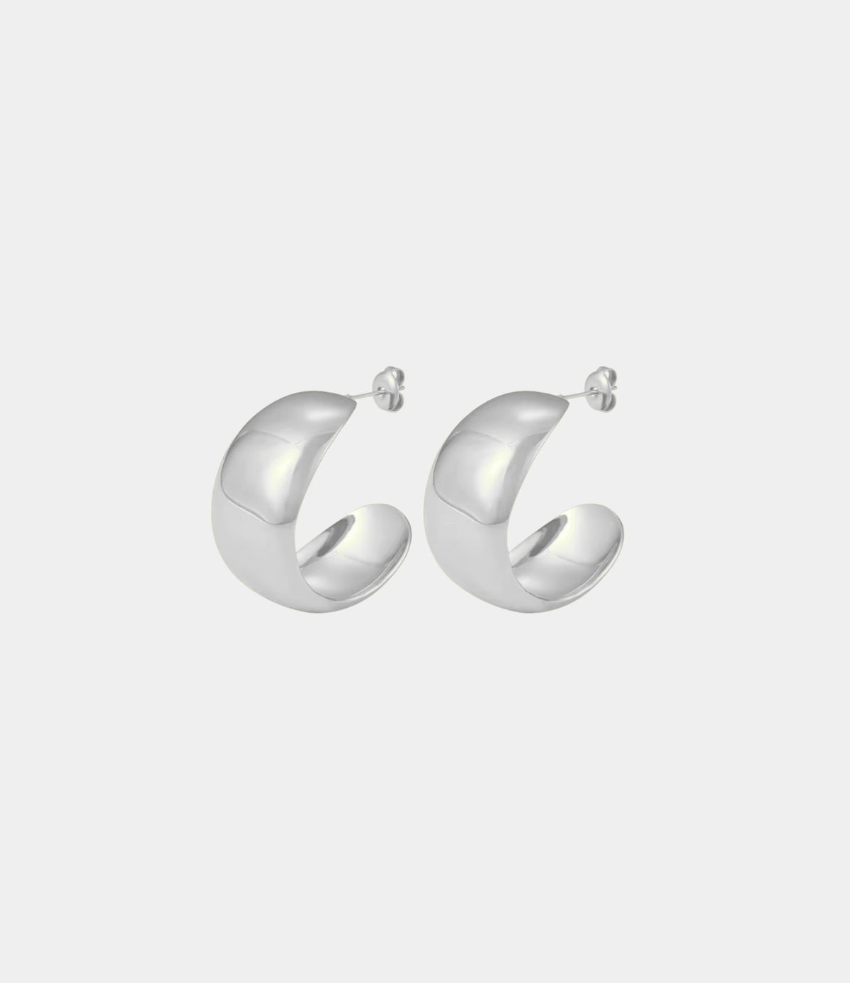LOLA EARRINGS are a pair of polished silver-tone hoop earrings with a chunky, sculptural open shape and stud backs.
