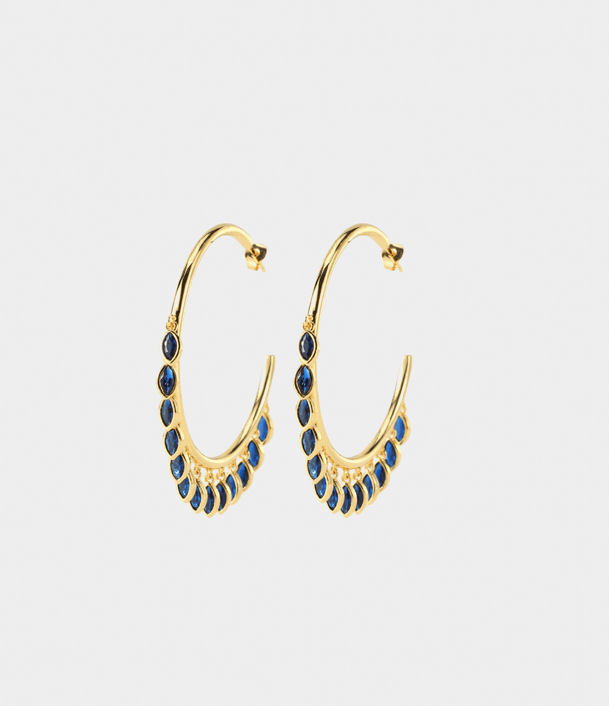 VIVIAN EARRINGS IN BLUE, gold-tone hoop earrings with rows of deep blue teardrop-shaped stones along the lower curve.