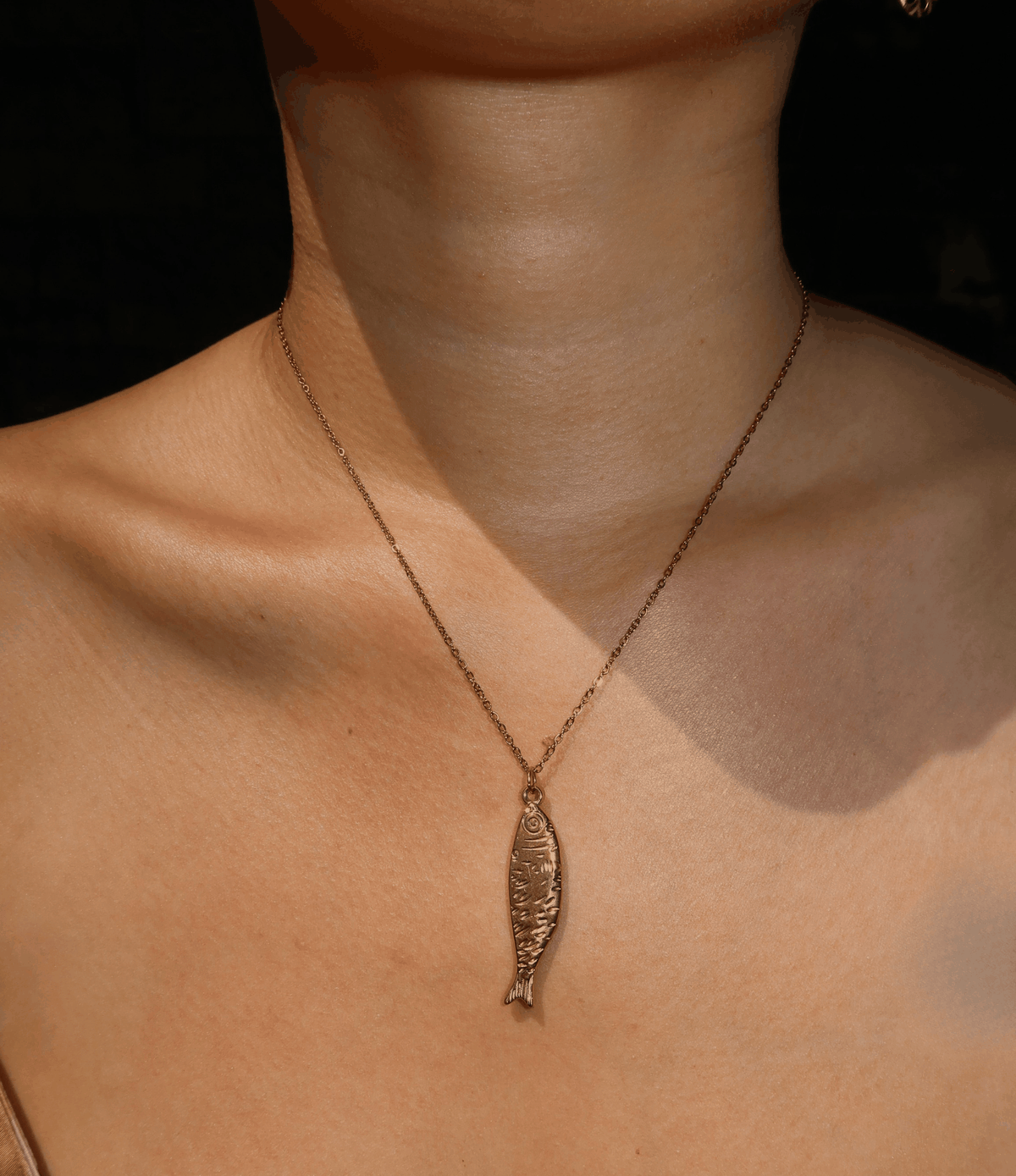 ATHENA FISH NECKLACE with a slim bronze-tone chain and textured fish-shaped pendant in a sculptural design