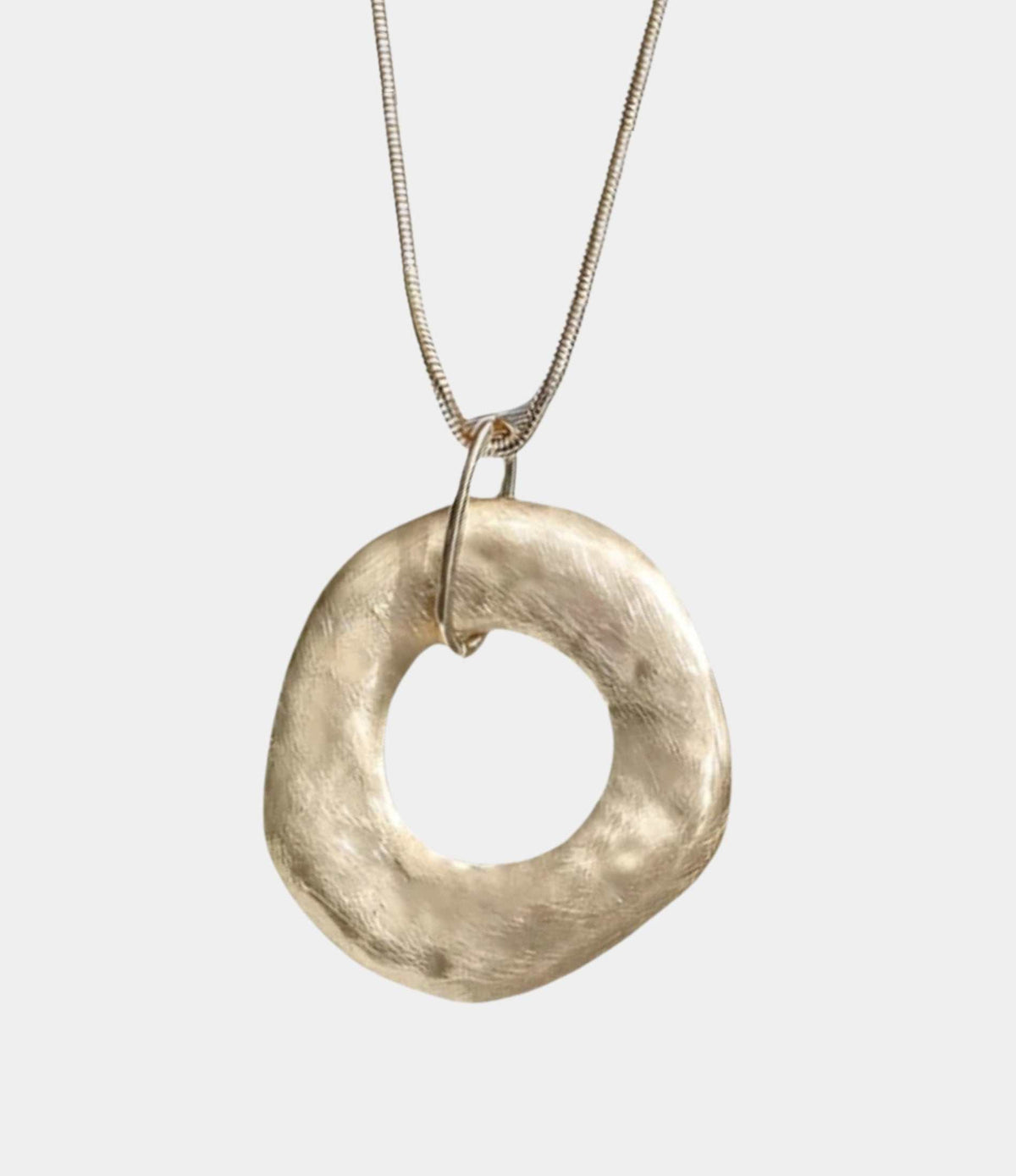 DELILAH PENDANT NECKLACE with a gold-tone metal chain and a large irregular circular pendant with a textured finish