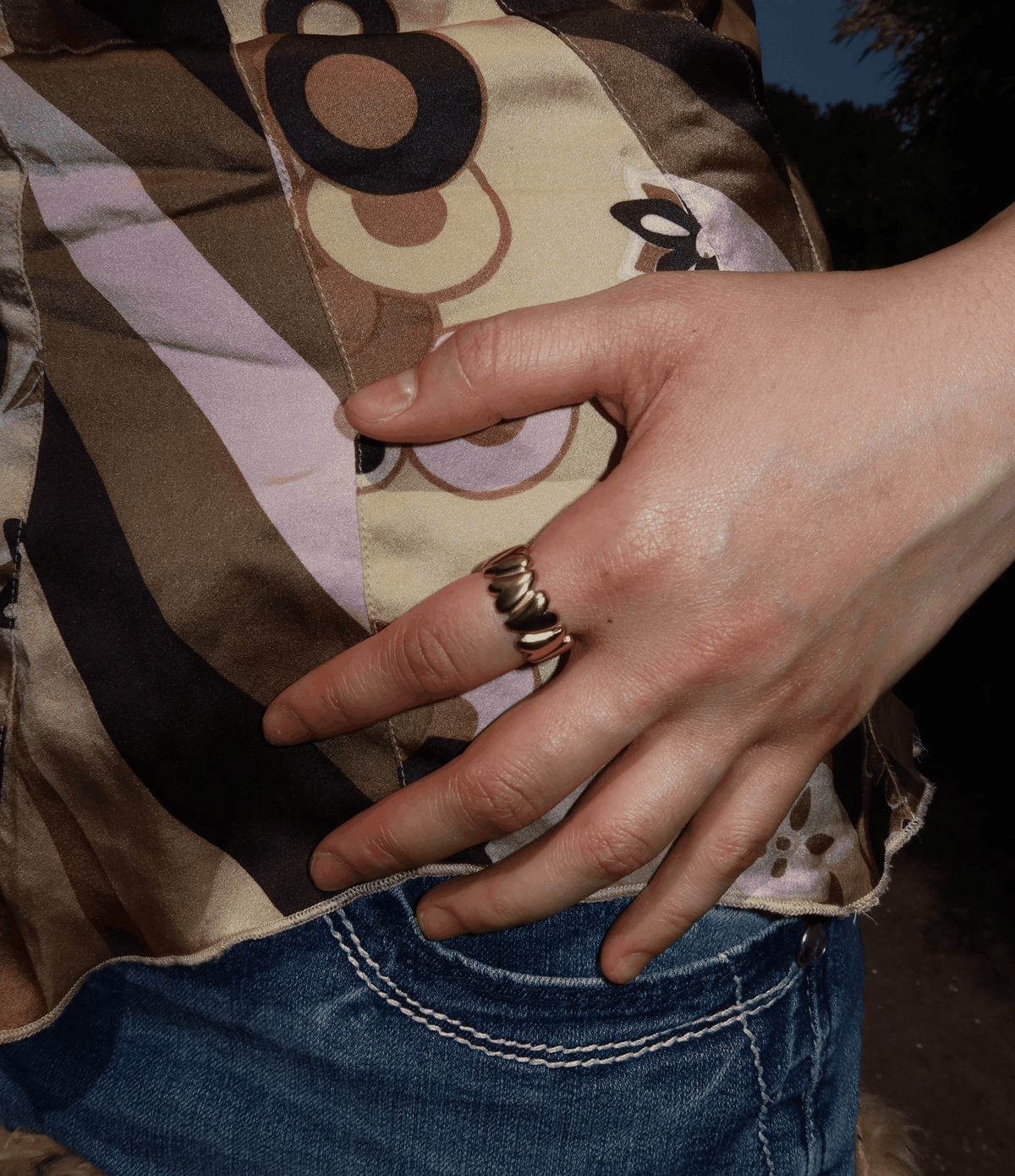 MARGO RING, gold-tone sculptural ring with a stacked, wavy design worn on a hand