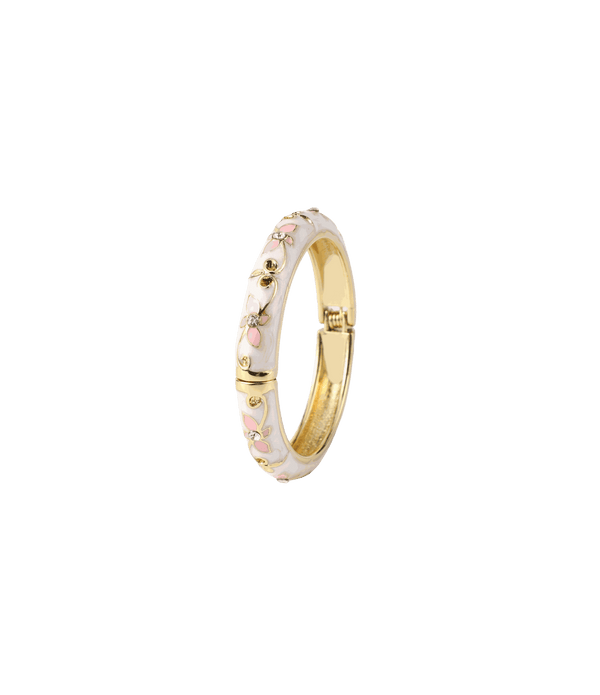 PETIT FLEUR BANGLE with a white enamel band, pink floral pattern and gold-tone metal interior and clasp.