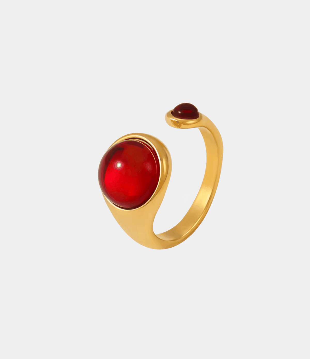 POMELO RING with a glossy cherry-red oval stone, gold-tone metal band, and distinctive open-ended design