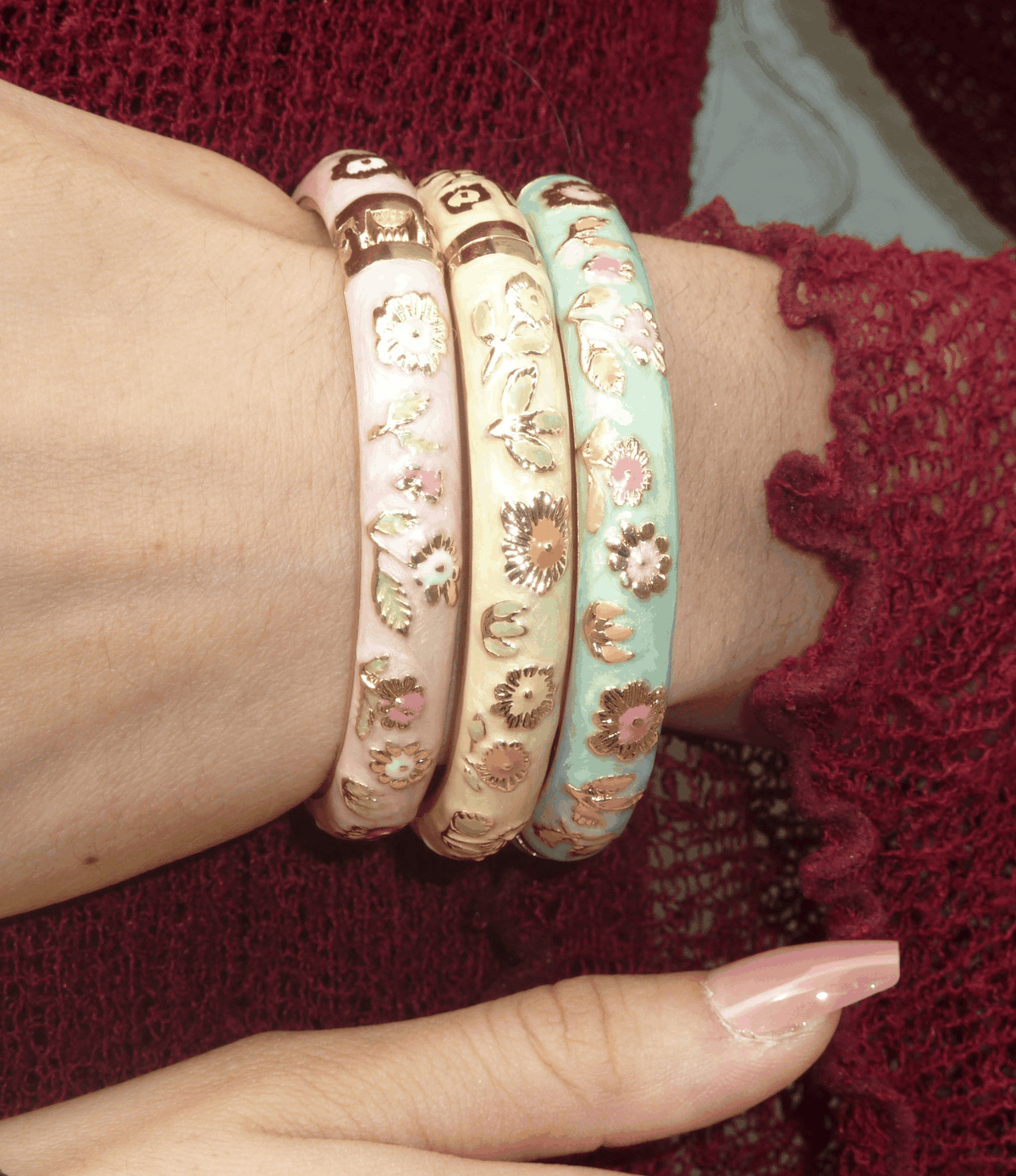 POPPY BANGLE IN PINK is a glossy cloisonné enamel bangle with raised floral details and a gold-tone rim.
