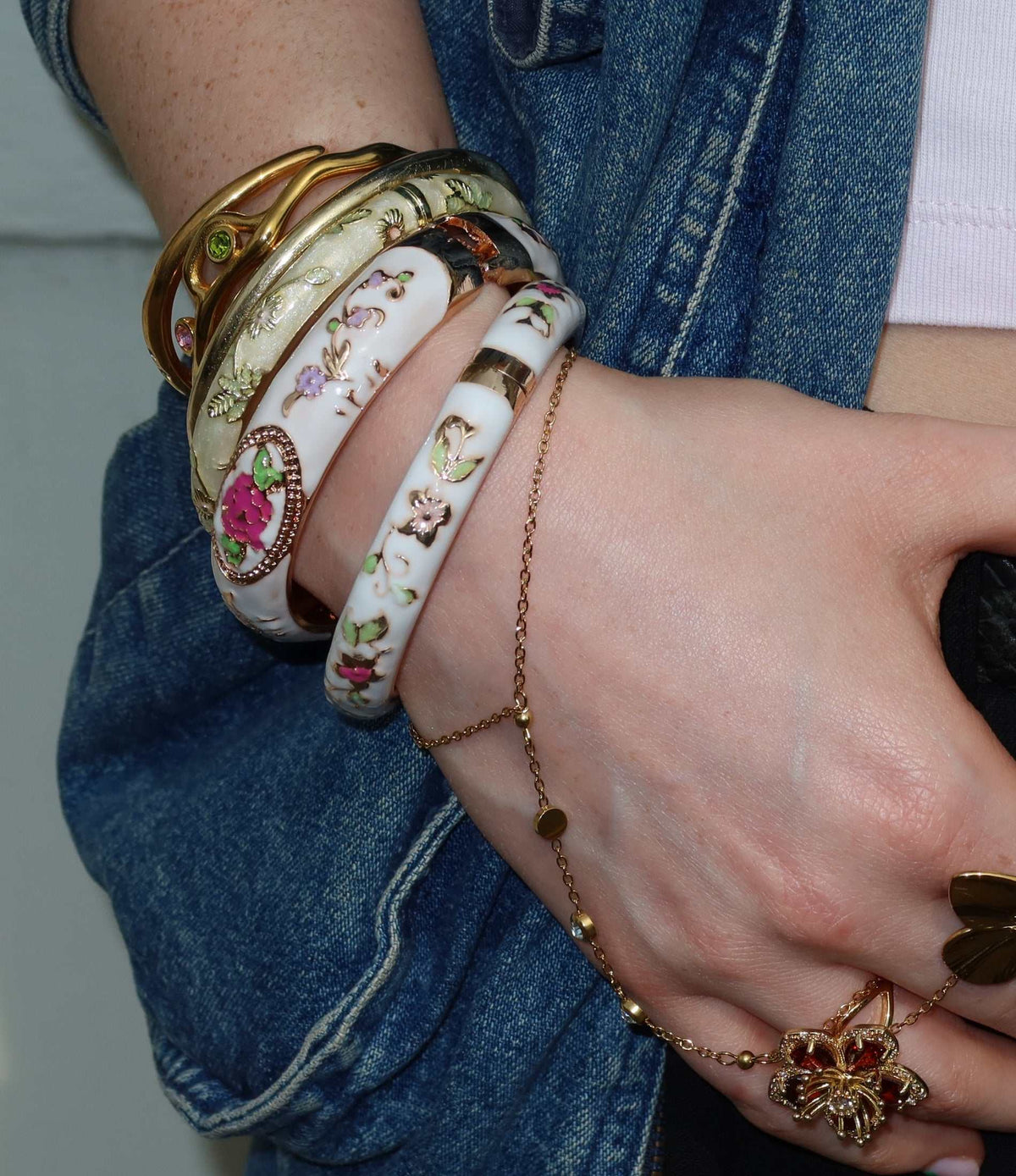 VENICE ENAMEL BANGLE in white enamel with delicate multicoloured floral motifs and gold-tone edging, worn stacked