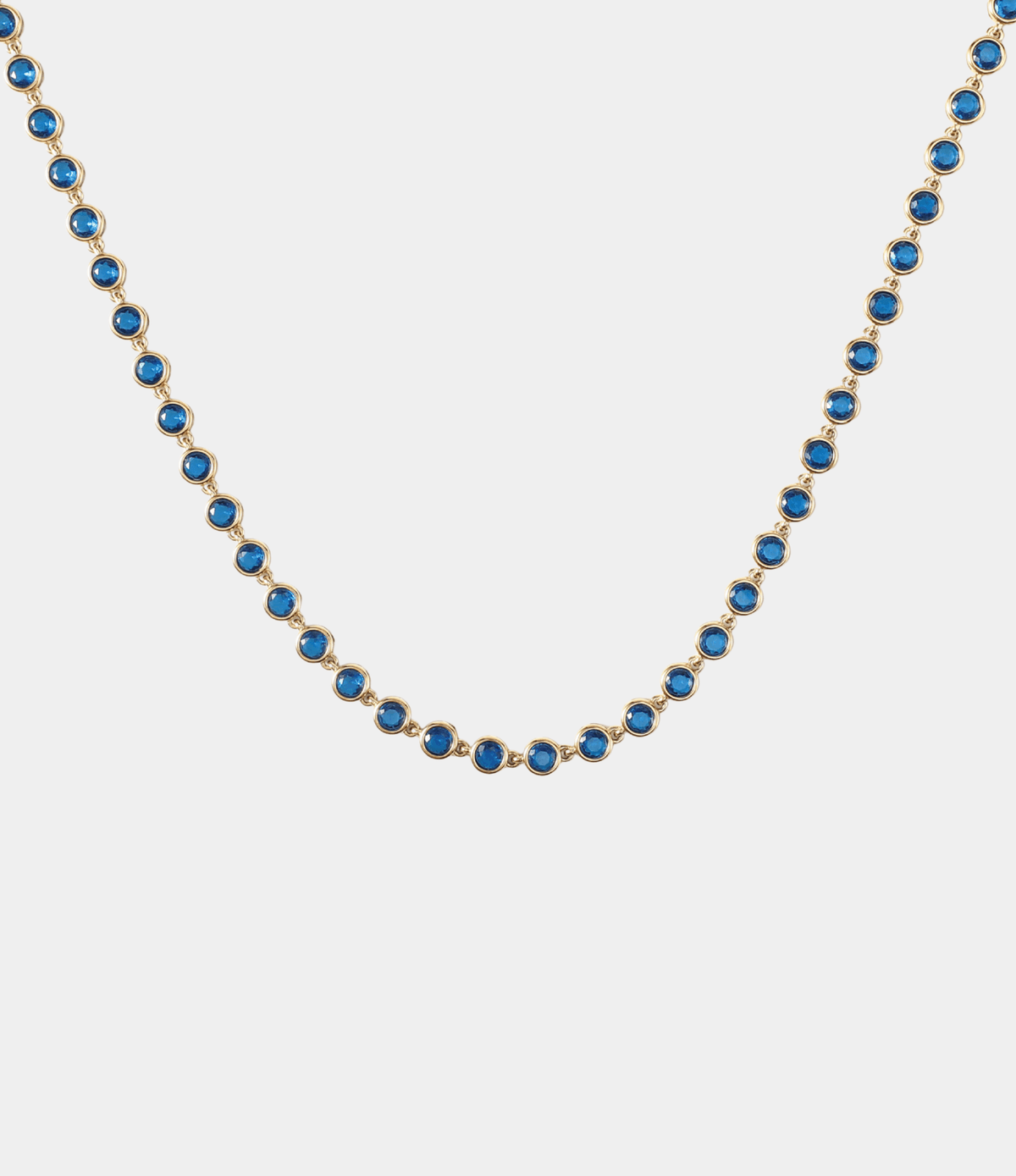VIVIAN TENNIS NECKLACE with a row of vivid blue round stones in gold-tone settings on a fine chain
