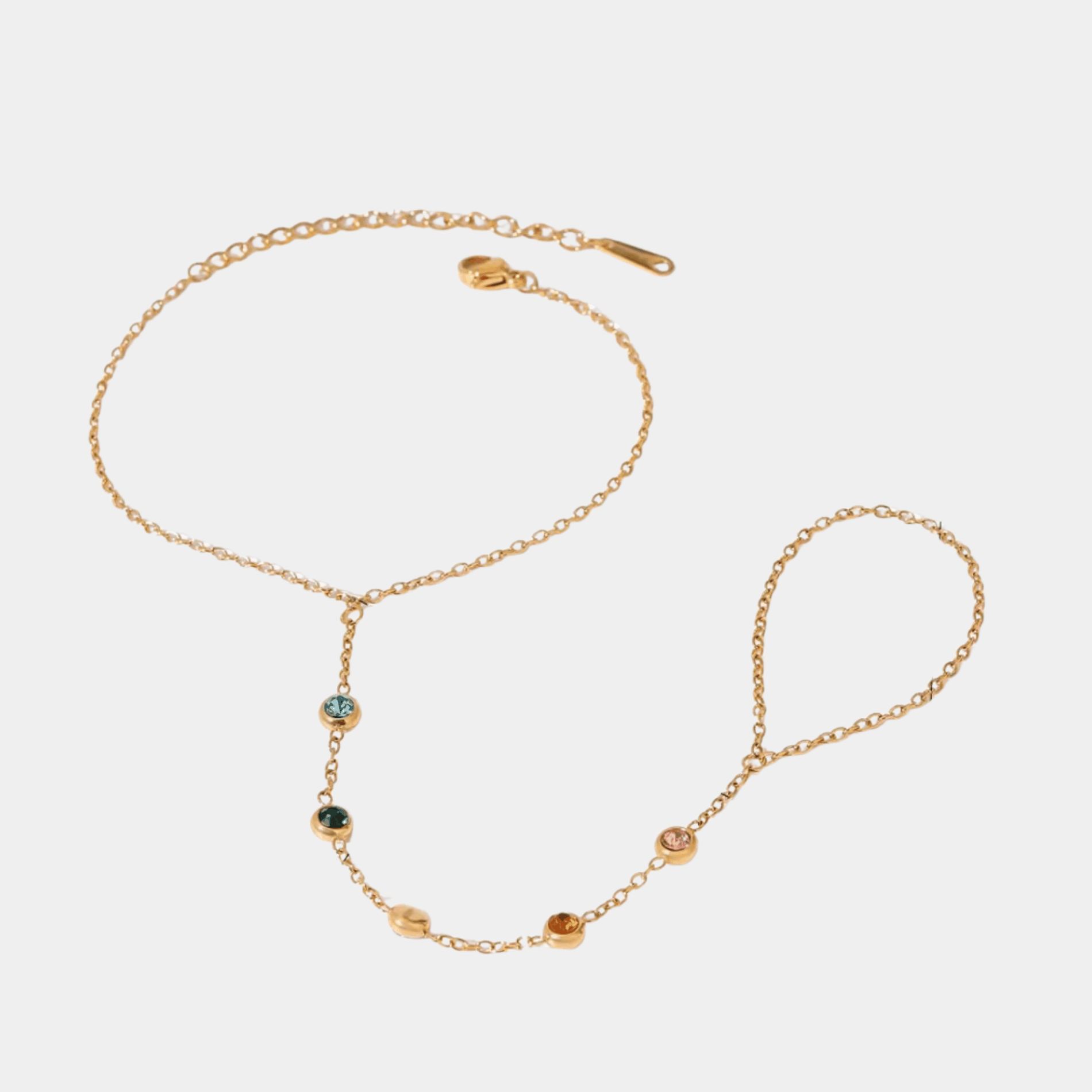 ADA BRACELET gold-tone metal hand-chain bracelet with delicate linked chain and small multicoloured stones, connecting to a finger ring.