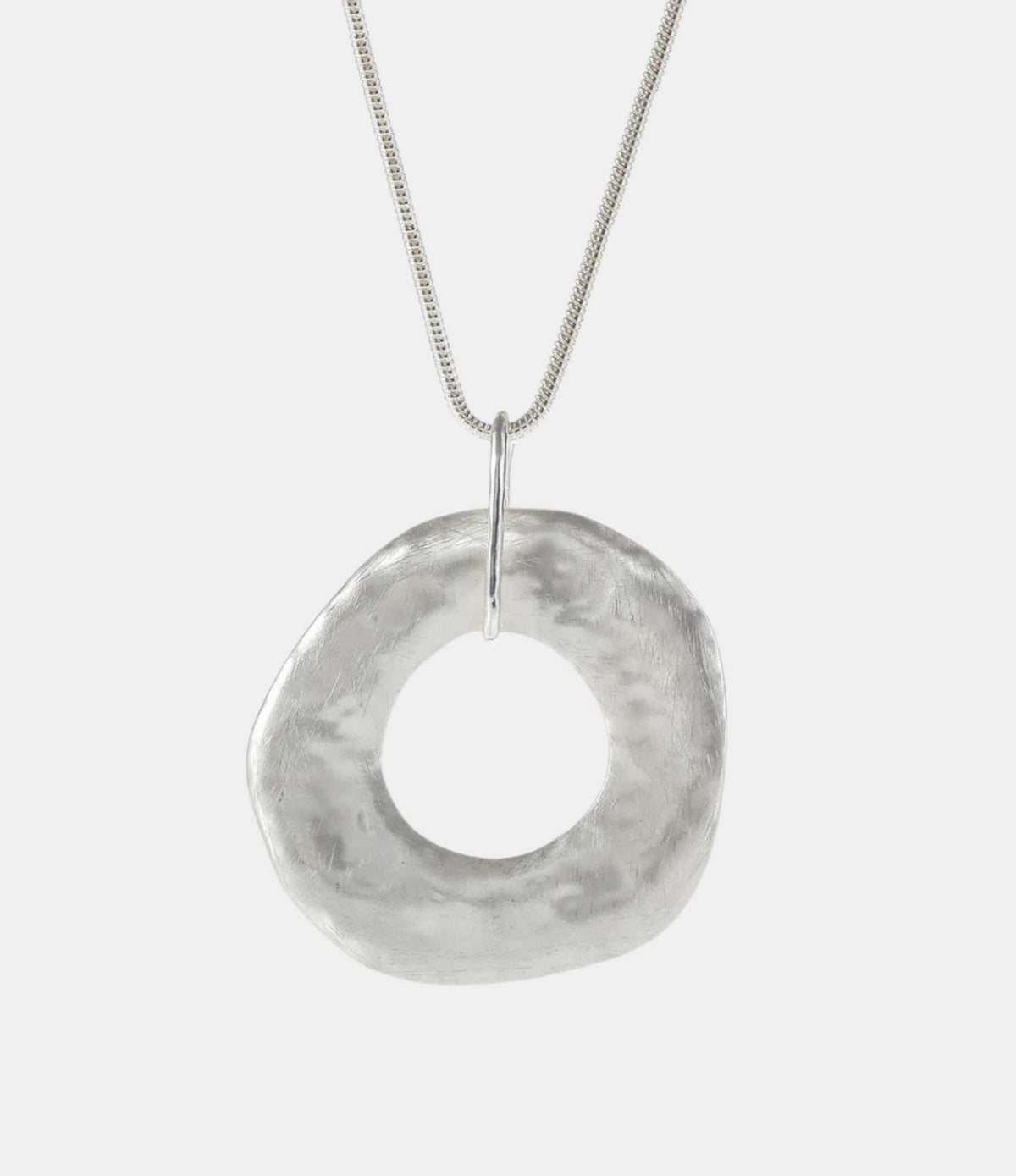 DELILAH PENDANT NECKLACE in silver-tone metal, featuring a long chain and a large, hammered circular ring pendant.