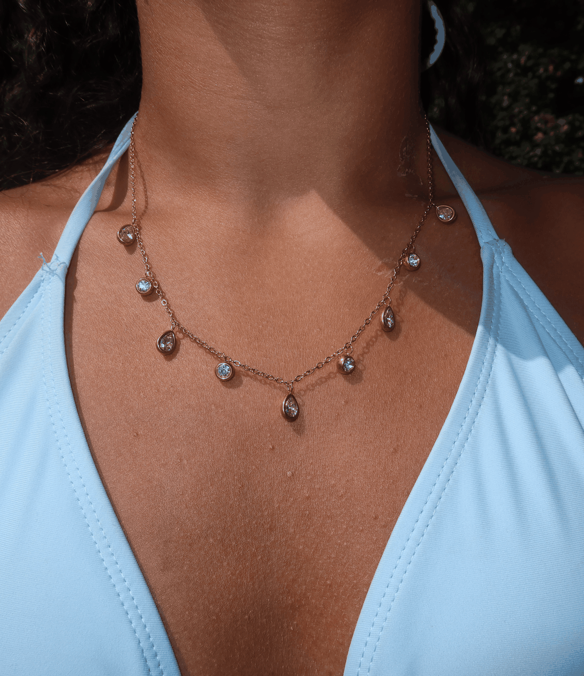 Diana Necklace in Pink, a delicate rose-gold layered chain with small pink and clear teardrop-shaped charms