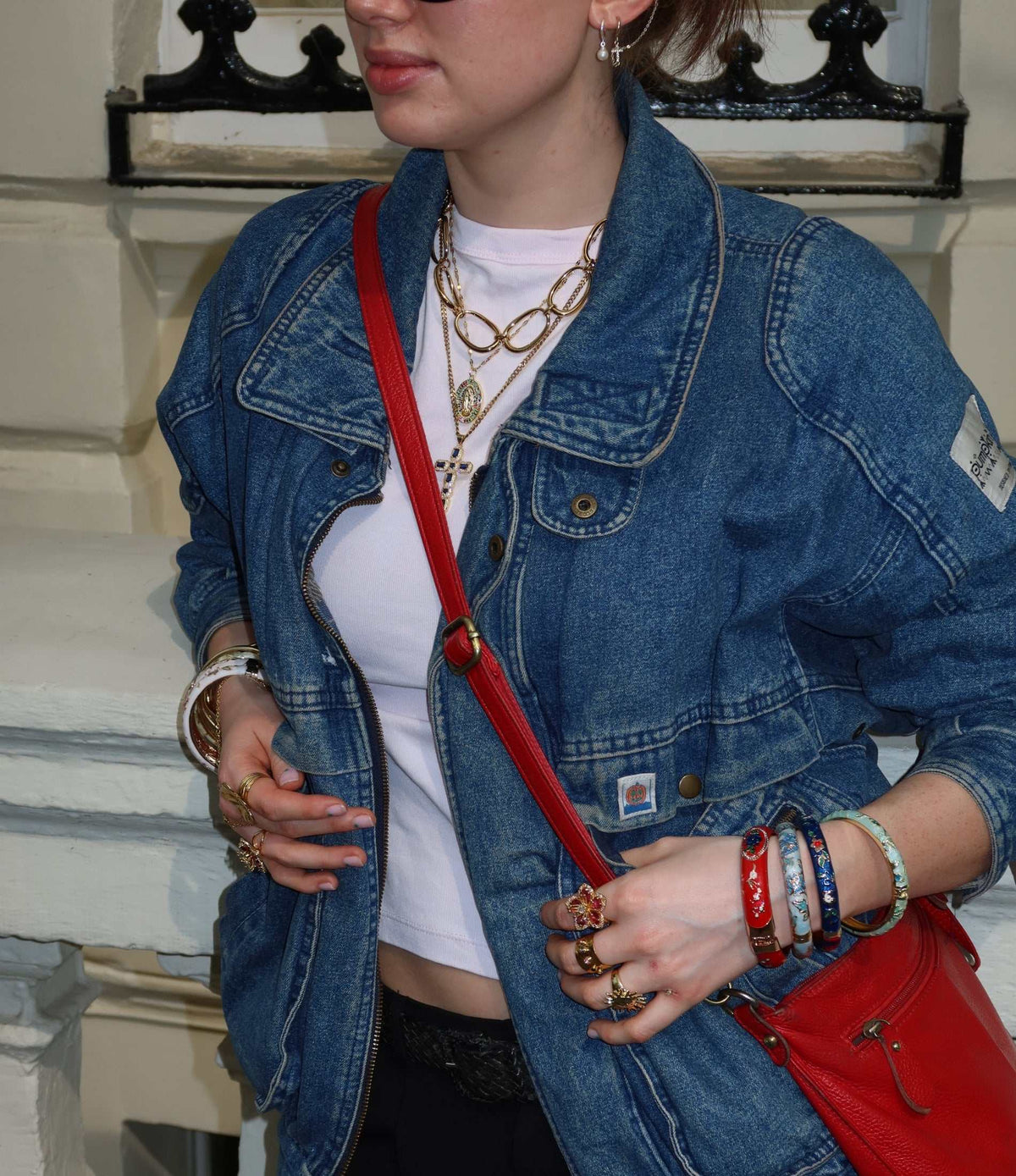 Divine Mary Necklace with a gold-toned chain and small oval religious pendant, layered with other necklaces