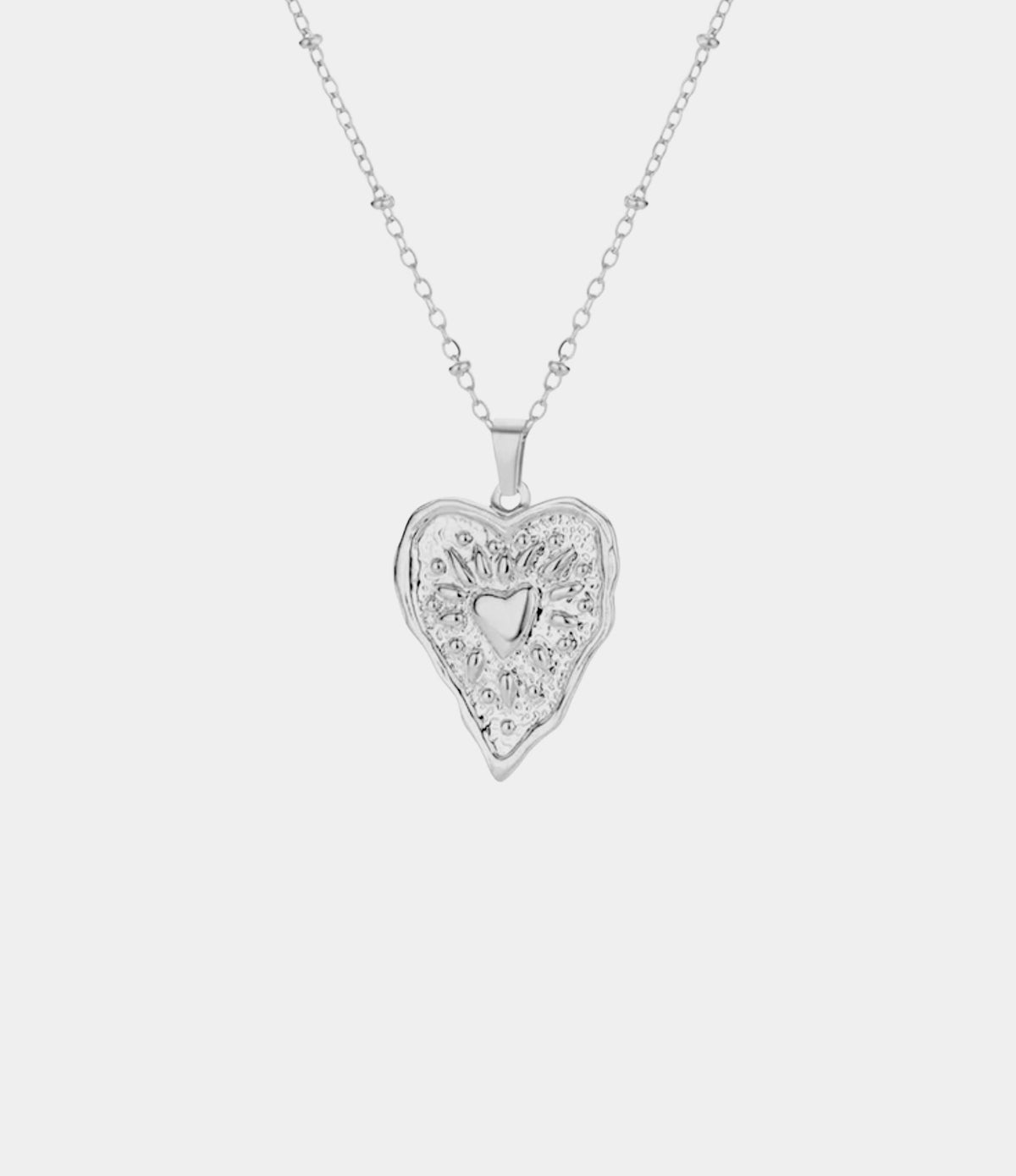 GRACE NECKLACE silver-tone chain pendant with an ornate heart-shaped design and small heart cutout