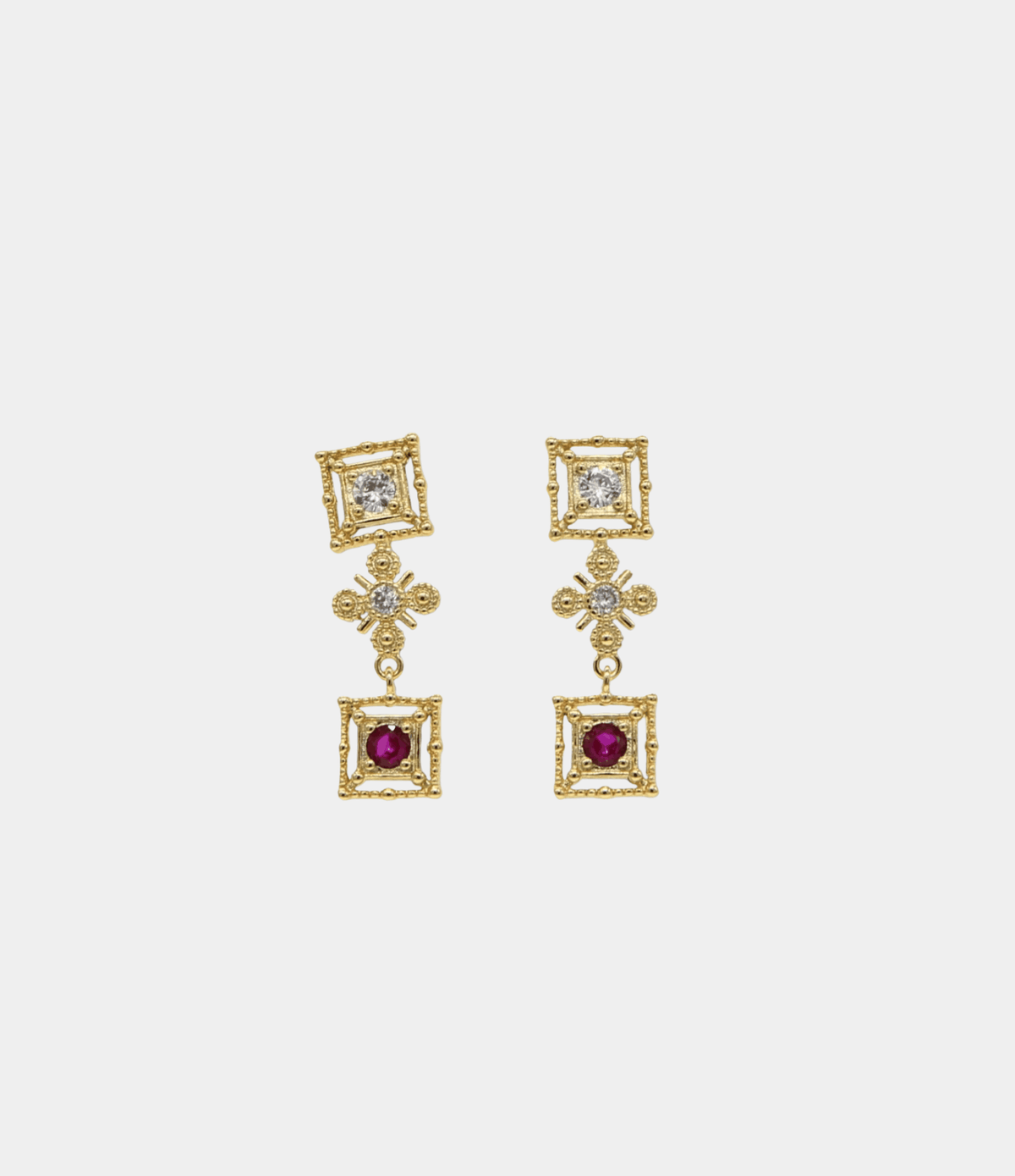 Maria Earrings are gold-toned drop earrings with ornate square frames, clear stones, floral details and deep magenta square gems.
