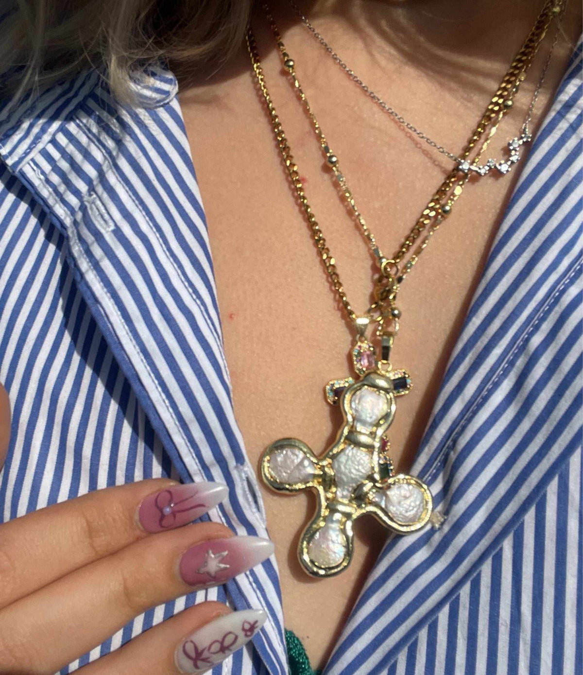 Olympia Necklace in gold-tone metal, featuring a bold chain and large sculptural four-lobed pendant with a textured centre