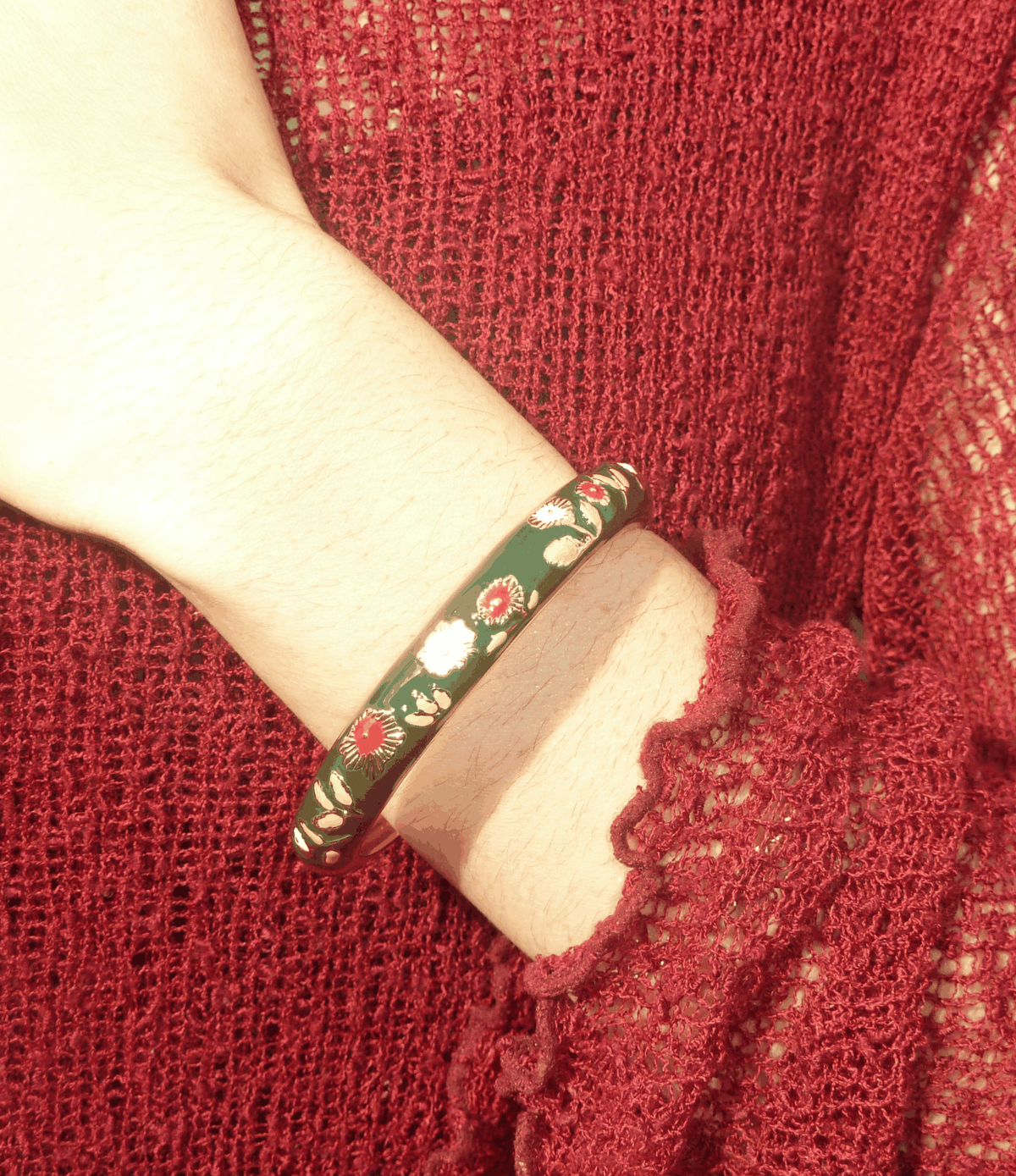 Poppy Enamel Bangle In Dark Green, a slim green enamel bracelet with gold-toned floral and red bud details