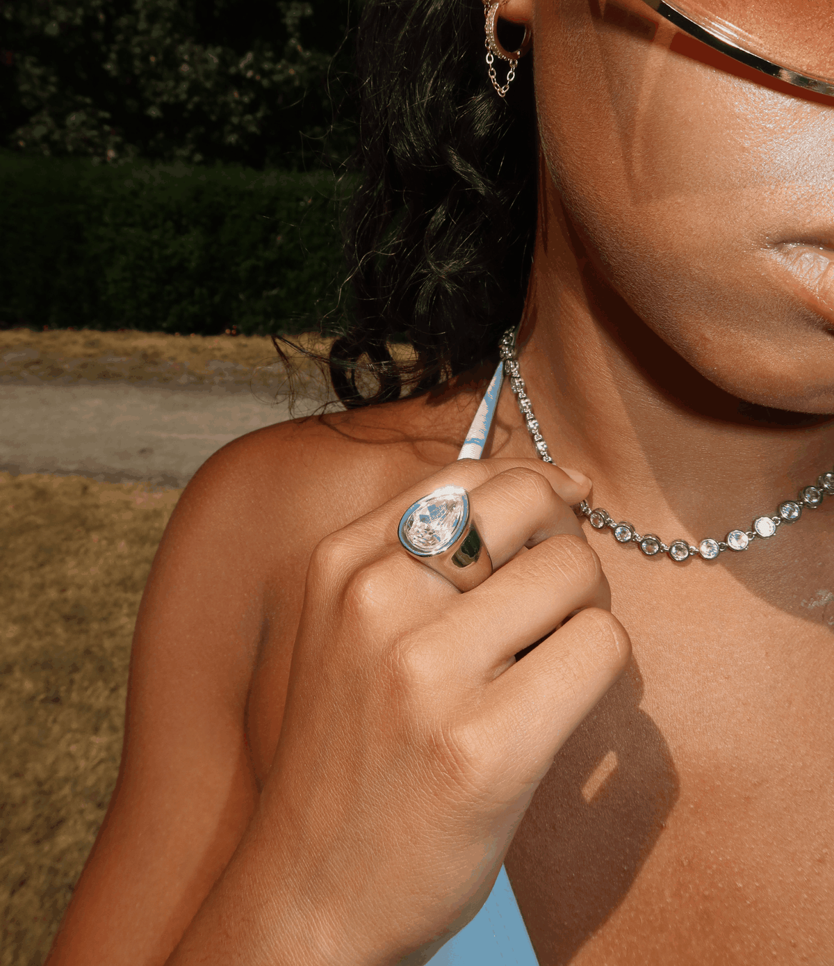 TEARDROP RING IN WHITE with a large oval teardrop face, clear blue-toned stone and polished silver-tone band