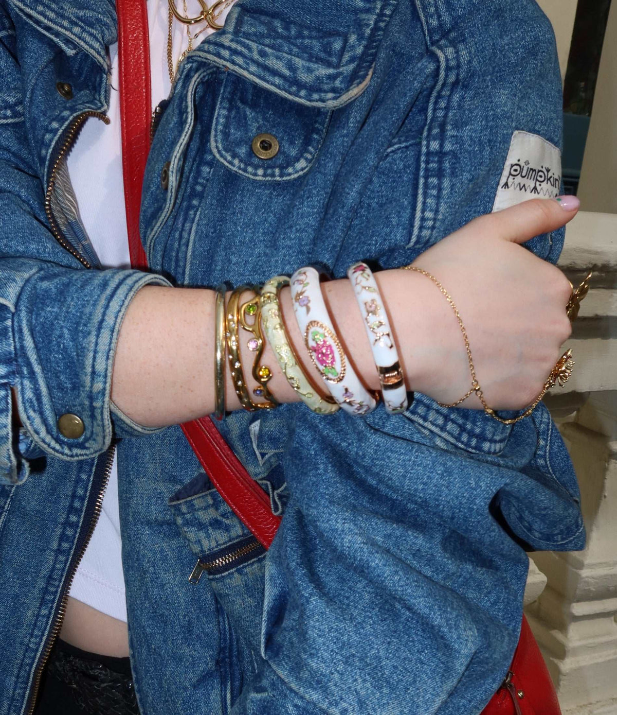 VENICE ENAMEL BANGLE in white enamel with delicate multicoloured floral details and gold-tone edging, worn stacked
